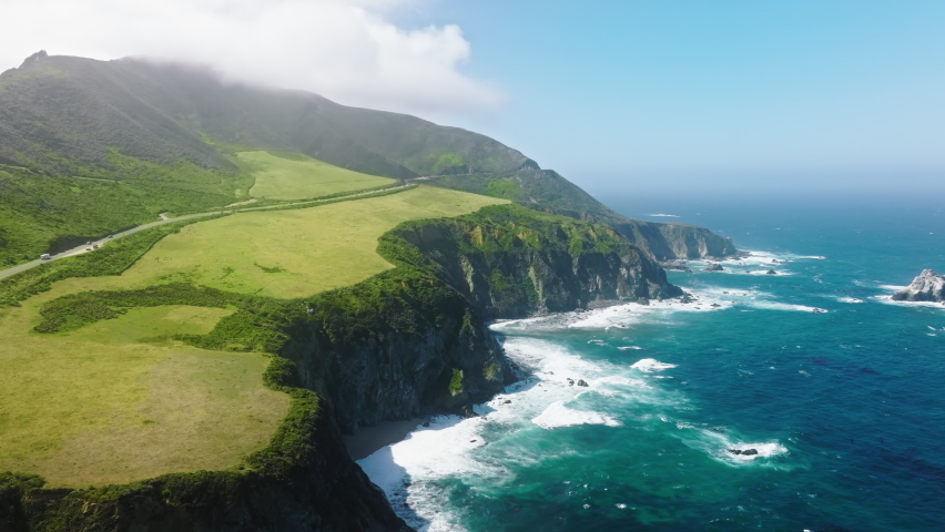 Scenic rocky coast nature background. Traveling pure nature of West Coast California USA. Cinematic aerial view of wild nature of the world famous Big Sur coastline. Outdoors adventure and travel 4K