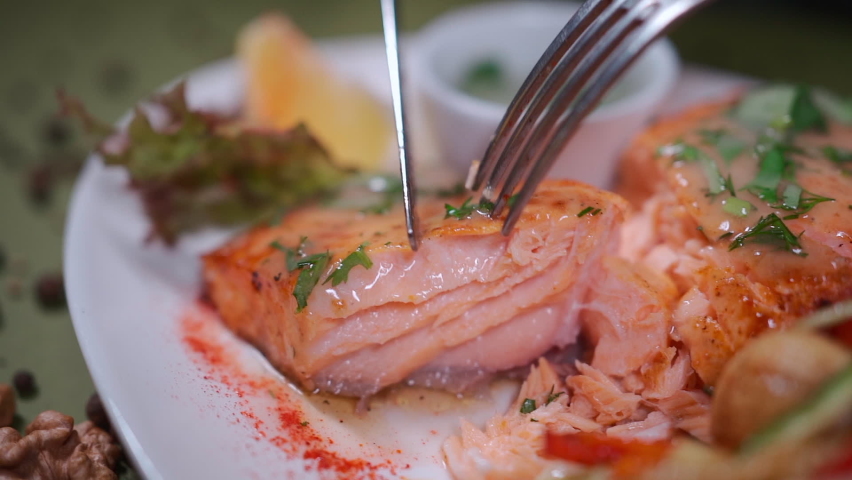 closeup of hand cutting roasted salmon steak on white plate with wok vegetable Royalty-Free Stock Footage #1093392125