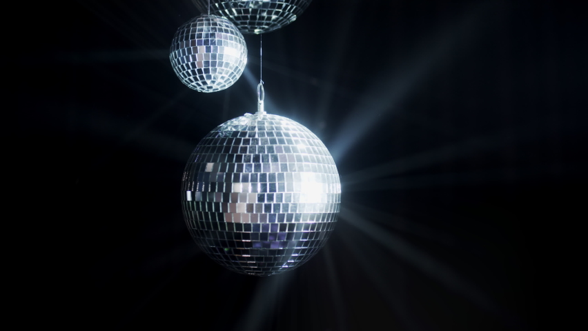 Disco Ball with Reflected Moving Rays Rotating. Mirror disco ball in white light. Isolated disco ball on black background. Close-up. Mirror ball spinning indoors. Performance. The reflection of lights | Shutterstock HD Video #1093402803