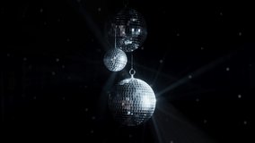 Disco Ball with Reflected Moving Rays Rotating. Mirror disco ball in white light. Isolated disco ball on black background. Close-up. Mirror ball spinning indoors. Performance. The reflection of lights