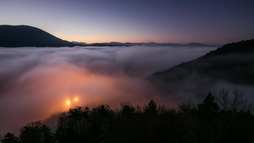 Time lapse at night over clouds with forest and mountain