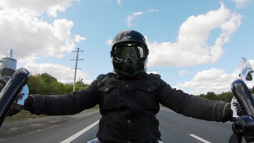 Man in black biker gear, helmet and reflective glasses riding motorcycle bike on the road racing, highway fast, face forward, action camera view from the handle steering wheel, outdoors | Shutterstock HD Video #1093417095