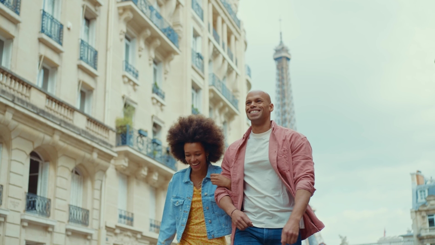 Happy multiethnic beautiful couple in love visiting Paris. Young man and woman on vacation in the french capital city, walking and doing activities around the eiffel tower area	 Royalty-Free Stock Footage #1093419969
