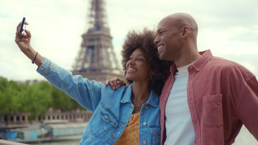 Happy multiethnic beautiful couple in love visiting Paris. Young man and woman on vacation in the french capital city, walking and doing activities around the eiffel tower area	 | Shutterstock HD Video #1093419999