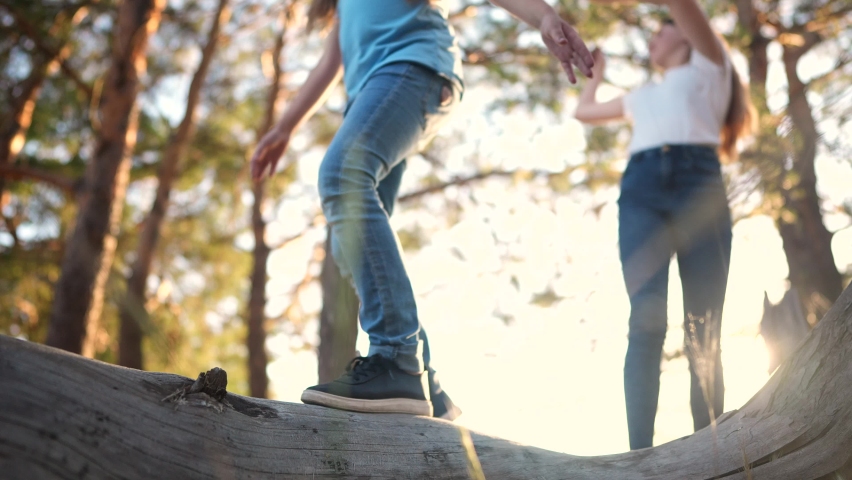 father and son in the park. . happy family kid concept. legs close-up children walk and play on a fallen tree in a forest park. a group of children play in dream woods running their feet up a tree