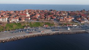 Bird's-eye view of a small newly built deck of a small resort ancient town - the peninsula of Pomorie with many different modern boats and boats, in the big salty calm Black Sea. UHD 4K video