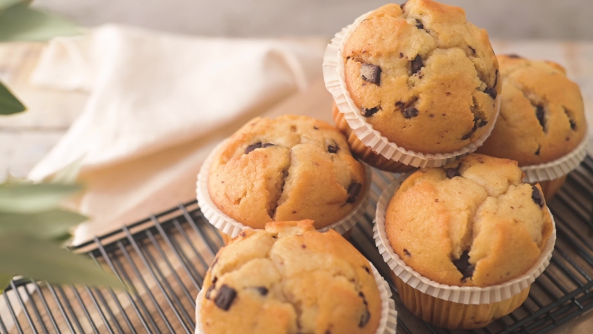 Chocolate chip muffins with milk served on glass cups on white kitchen countertop. Royalty-Free Stock Footage #1093426939
