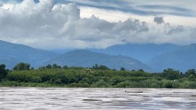 High mountains with beautiful white clouds. The Mekong River flows during the rainy season. Video time-lapse of mountains and rivers.