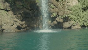 waterfall flowing into lake through mountains