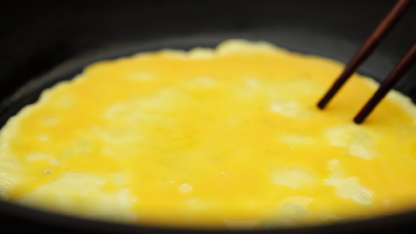 Cooking fluffy scrambled eggs close up Royalty-Free Stock Footage #1093437137