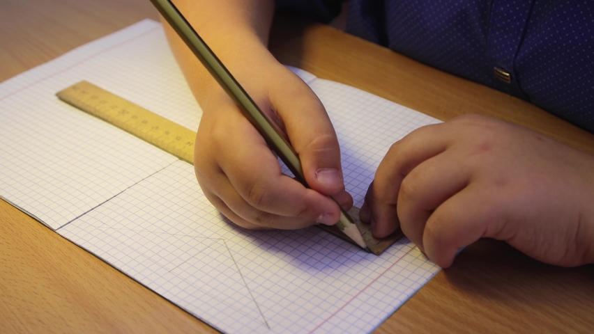 The student's hands draw a rectangle with a pencil using a ruler. Schoolboy is on a mission. Educational school concept.Elementary and middle school. UHD 4K. Royalty-Free Stock Footage #1093437647