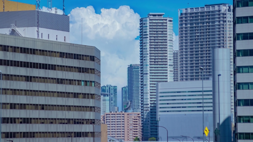 A timelapse of cloud reflecting the building in the business town long shot tilt. High quality 4k footage. Minato district Shiodome Tokyo Japan 07.25.2022 Here is a center of the city in Tokyo.  Royalty-Free Stock Footage #1093439247
