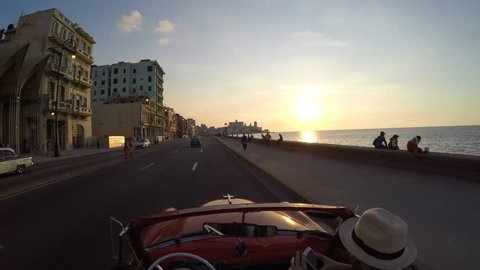 Driving classic convertible car wIth sunset in Havana, Cuba