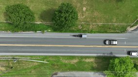 Amish horse and buggy in slo-motion. Top down aerial of car following carriage on road, approach railroad crossing. Can speed up clip.