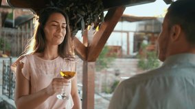 Beautiful young woman enjoying date flirting with man couple drinking wine making toast celebrating on the terrace in the yard - Powered by Shutterstock - Get 15% off with code: PIKWIZARD15