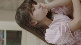 Little girl comforting her sad friend. She comforts him in his room and hugs him to calm him down. The girl rests her head on the shoulder of her beloved friend.Vertical video.