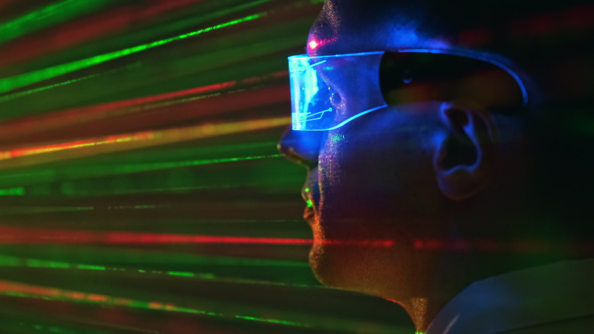 The man in transparent futuristic glasses on a laser rays background