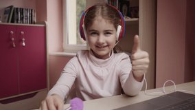 Distance Learning Schoolgirl Studying Online Using Laptop Making Thumbs up. School Student in Headphones Approved Distance Learning Showing Thumbs up. Caucasian Girl Wear Headphones Learn Online Class - Powered by Shutterstock - Get 15% off with code: PIKWIZARD15