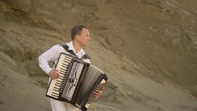 man in white playing black accordion