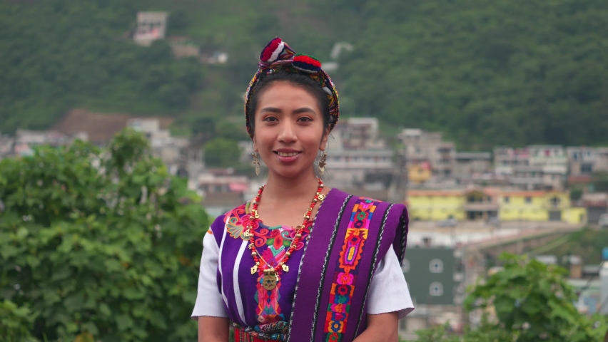 Beautiful Hispanic woman looking at the camera with the mountains and town in the background. | Shutterstock HD Video #1093478249