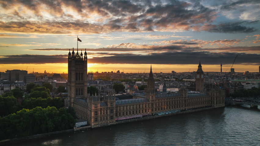 Establishing Aerial View Shot of London UK, United Kingdom, Westminster, sun peaks from behind Elizabeth Tower, magical sunset over parliament, Big Ben Royalty-Free Stock Footage #1093481913