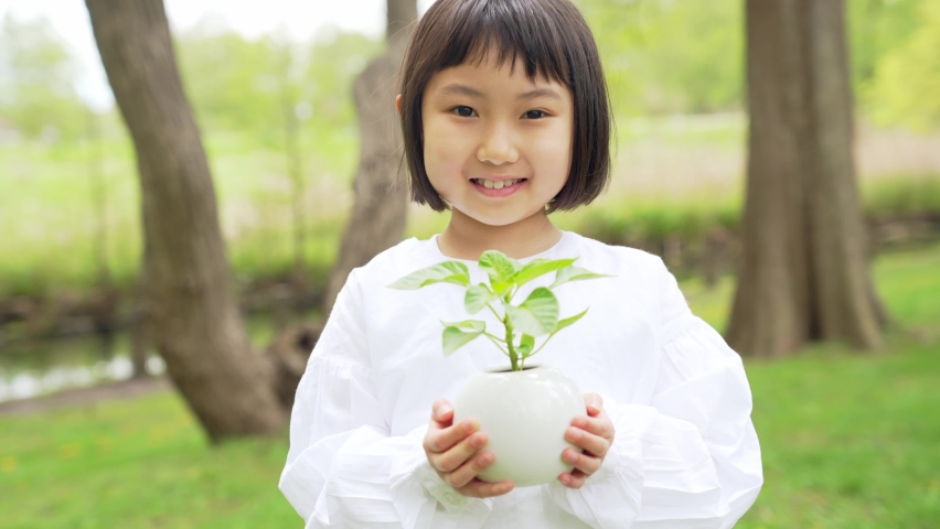 Asian little girl holding a little plant. Environment protection concept. Sustainable lifestyle. Royalty-Free Stock Footage #1093482297