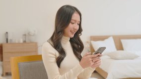 Asian girl using smart phone playing game and social media or chatting with her friends.