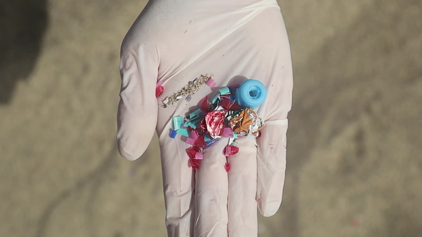 Micro plastic that found , woman cleans microplastic from sand on the beach | Shutterstock HD Video #1093484625