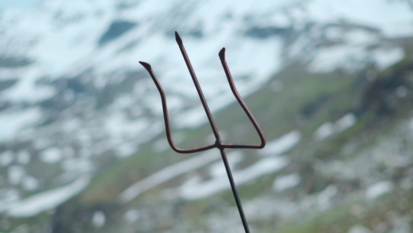 Shiva Trishul in background of snow Himalayan mountain at Rohtang pass at Manali, Himachal Pradesh, India. Trident  of lord shiva in front of snow covered mountains. Rack focus shot | Shutterstock HD Video #1093485575