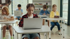 School girl is studying using laptop sitting in the class room during computer science lesson. Elementary school. Learning and education concept - Powered by Shutterstock - Get 15% off with code: PIKWIZARD15