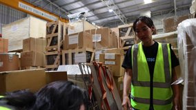 Two women worker carrying and lifting heavy cardboard box. Asian obese female warehouse worker in safety vest and hardhat helmet working in warehouse factory industrial. - Powered by Shutterstock - Get 15% off with code: PIKWIZARD15