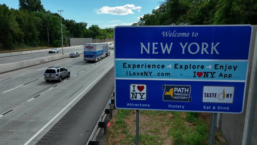 New York , NY , United States - 08 13 2022: Welcome to New York State. Road sign along highway. Rising aerial.