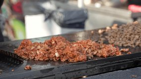 This close up, slow motion video shows the hands of a chef chopping al pastor taco meet and cooking it on our outdoor grill.