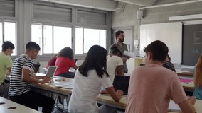 Young male teacher explaining during a science class at the university to a group of multi-ethnic students. University Teaching - Powered by Shutterstock - Get 15% off with code: PIKWIZARD15