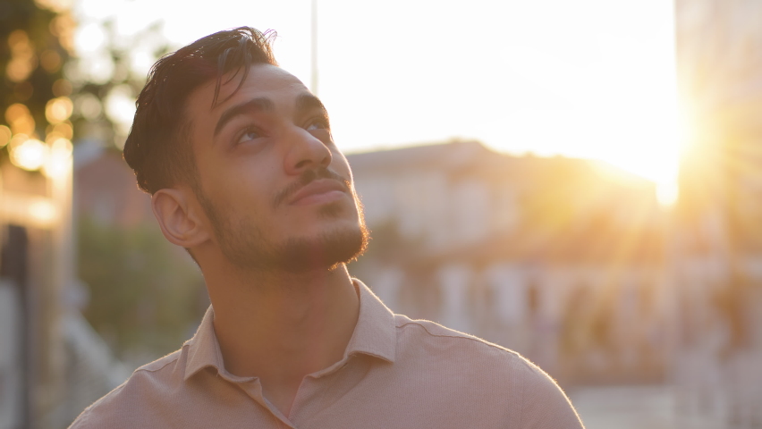 Close-up pensive inspired Indian Latin Arabic Hispanic bearded male boss worker man in formal shirt outdoors looking at sky thinking. Portrait businessman stands in city street in sunset sun Royalty-Free Stock Footage #1093498449