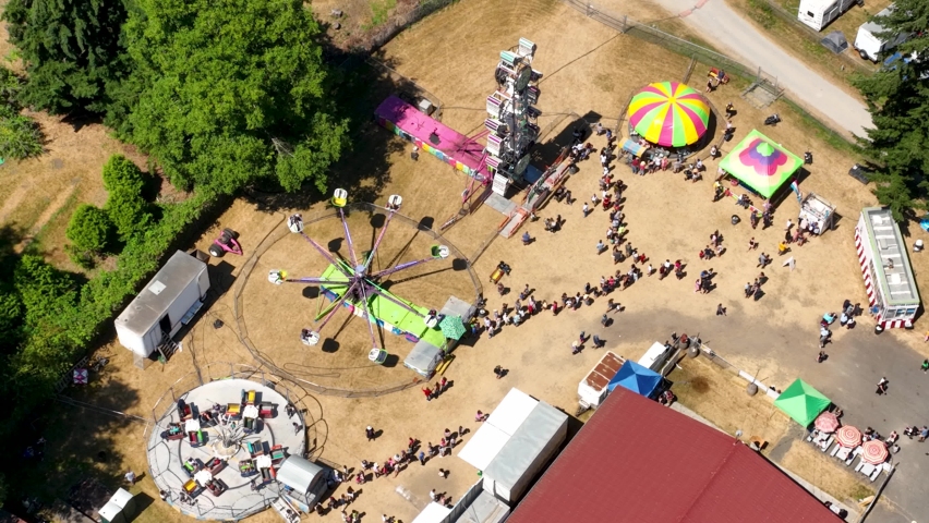 Overhead aerial shot of spinning rides and long lines at a fair in America. Royalty-Free Stock Footage #1093509081