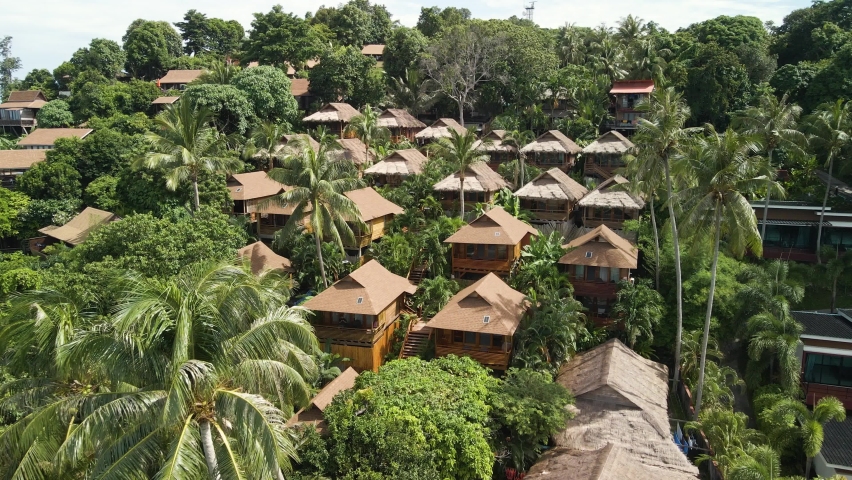 Aerial flyover of a village on Ko Lipe Island, Thailand nestled amongst the tropical vegetation.  Royalty-Free Stock Footage #1093510521