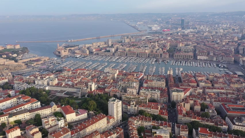 Picturesque drone view of modern Marseille cityscape on Mediterranean coast overlooking large Old Port with moored pleasure yachts on sunny day, France