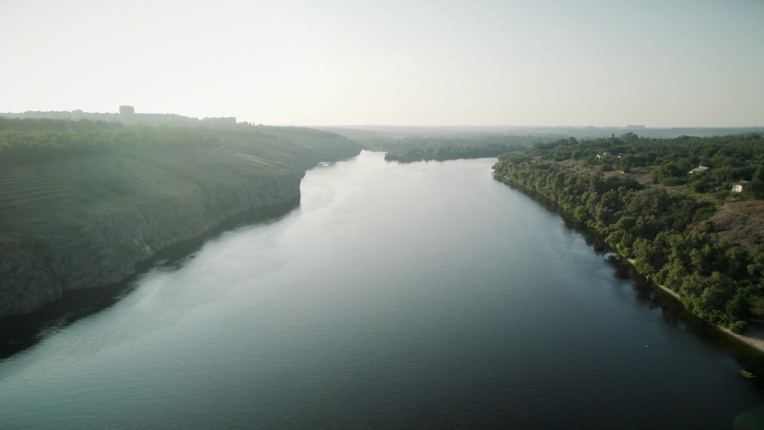 Aerial view of the wide river with two green shores 4K