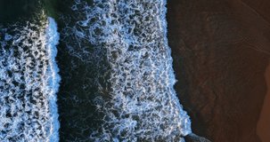 Top-down ocean wave Aerial video beautiful closeup shot beach and seawater on wave on sand in sunset time (Top-view) nature and travel concept video.