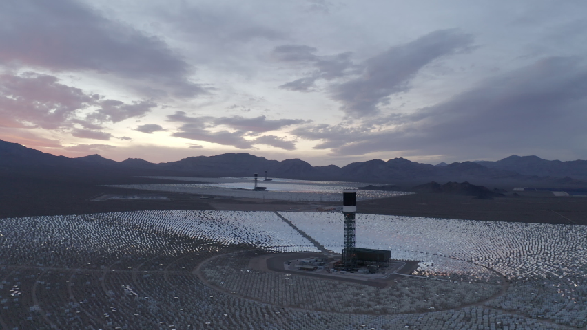 Aerial Panning Shot Of Tall Towers Amidst Solar Panels In Company At Mojave Desert - Nipton, California