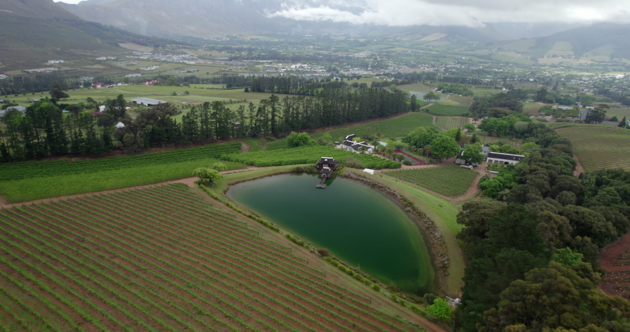 Aerial Beautiful Shot Of Residential Town Under Clouds, Drone Flying Forward Over Agricultural Field - Cape Town, South Africa