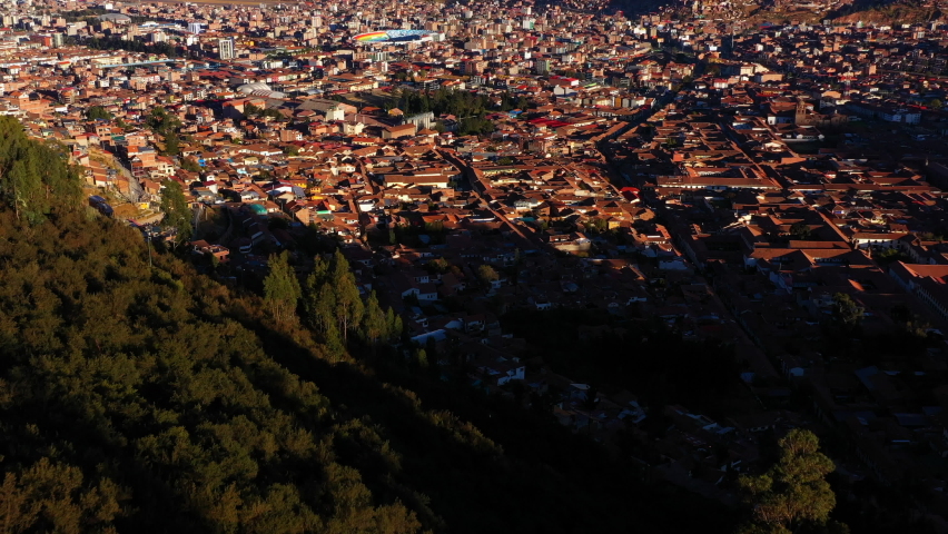 Aerial Forward Shot Of Stadium Amidst Residential Houses In City By Mountains - Cusco, Peru