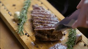Hot delicious beefsteak cutting on a wood cutting board with a knife