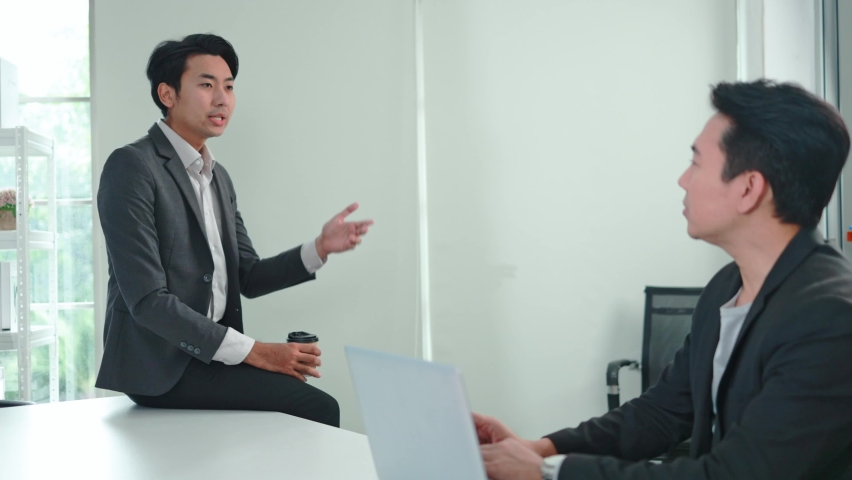 Two Asian business men discuss marketing strategies at the office. business people discuss project planning with friends