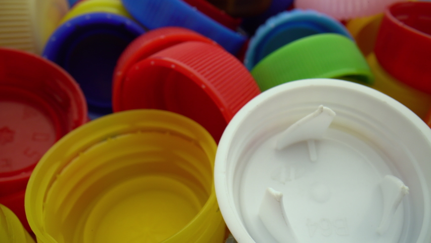Used plastic bottle caps close-up. Macro shot of garbage from plastic lids. Dolly shot Royalty-Free Stock Footage #1093543223