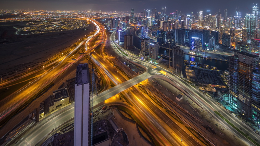 Panorama showing skyline of Dubai with business bay and downtown district night timelapse. Aerial view of many modern skyscrapers and busy traffic on al khail road. United Arab Emirates.