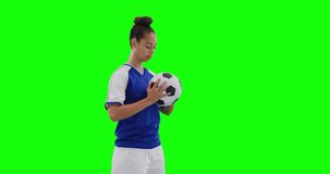 Video of caucasian female football player holding football and copy space on green screen. Female football, female sports and competition concept.
