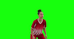 Video of caucasian female football player head kicking football and copy space on green screen. Female football, female sports and competition concept.