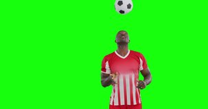 Video of african american male soccer player head kicking ball on green screen background. Soccer, football, sports and competition concept.